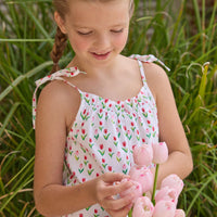 Little English traditional children's clothing. White romper with red and pink tulip print and self-tie straps for little girls