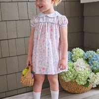 Little English traditional children's clothing. Classic peter pan dress with capped sleeves and a light blue sash in a light pink bunny print for little girls. Easter outfit for girls.