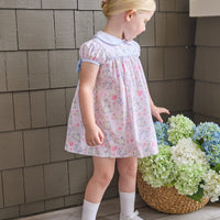 Little English traditional children's clothing. Classic peter pan dress with capped sleeves and a light blue sash in a light pink bunny print for little girls. Easter outfit for girls.