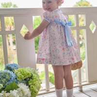 Little English traditional children's clothing. Classic peter pan dress with capped sleeves and a light blue sash in a light pink bunny print for little girls. Easter outfit for girls.
