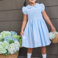 Little English classic smocked emery dress in light blue with white detailing, smocking around chest, tieable in back, for little girl