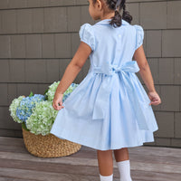 Little English classic smocked emery dress in light blue with white detailing, smocking around chest, tieable in back, for little girl