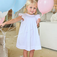 Little English traditional children's clothing. White flutter sleeve dress for toddler girls with rainbow smocking at the collar. Birthday dress for little girls