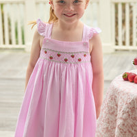 Little English traditional children's clothing. Light pink seersucker gingham dress for little girls with flutter sleeves and strawberry smocking across the chest
