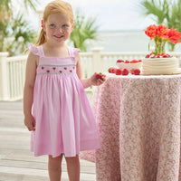Little English traditional children's clothing. Light pink seersucker gingham dress for little girls with flutter sleeves and strawberry smocking across the chest