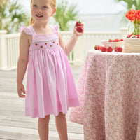 Little English traditional children's clothing. Light pink seersucker gingham dress for little girls with flutter sleeves and strawberry smocking across the chest