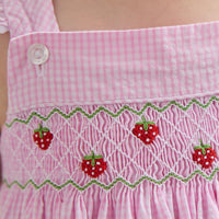 Little English traditional children's clothing. Light pink seersucker gingham dress for little girls with flutter sleeves and strawberry smocking across the chest