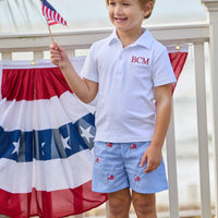 Little English traditional children's clothing. Blue gingham shorts with all-over American flag embroidery for boys. Boy's shorts for 4th of July.