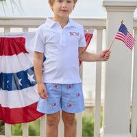 Little English traditional children's clothing. Blue gingham shorts with all-over American flag embroidery for boys. Boy's shorts for 4th of July.