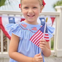 Little English traditional children's clothing. Flutter sleeve dress for toddler girls in royal blue mini gingham with smocking at the collar and American flag bunting