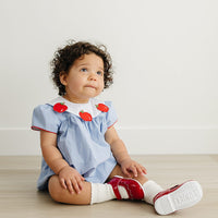 Little English traditional children's clothing. Short sleeve royal blue gingham bubble with white bib collar with applique apples for baby girls