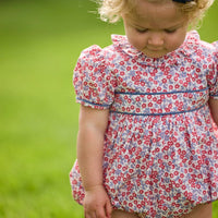 Little English traditional children's clothing. Soft blue and raspberry red Lennox Floral short sleeve bubble for baby girls with ruffle collar and blue piping detail at sleeves and chest