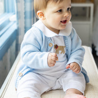Little English traditional baby clothes, signature white cotton playsuit with peter pan collar, light blue picot trim, and crochet lab. Accompanied by a crochet cardigan with lab motif on sides and back for baby boy.