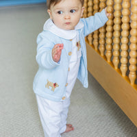 Little English traditional baby clothes, signature white cotton playsuit with peter pan collar, light blue picot trim, and crochet lab. Accompanied by a crochet cardigan with lab motif on sides and back for baby boy.