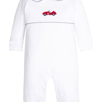 Little English traditional children's clothing. White pima cotton playsuit with peter pan collar, navy picot trim, and crocheted red race car at center of chest