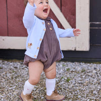 Little English traditional children's clothing company. Short sleeve peter pan bubble in chocolate brown corduroy with wood button details for baby boys. Paired with light blue cardigan with crochet abs on each side.
