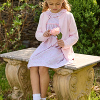 Little English traditional children's clothing. Long sleeve pink and green Windemere floral dress with ruffled collar and fixed bow detail for little girls. Layered with light pink bow pocket cardigan.