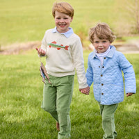Little English traditional children's clothing. Boys cream crew neck sweater with fish motif layered over light blue striped polo and paired with watercress green corduroy pants. Little boy wearing light blue quilted jacket with watercress green corduroy pull on pants