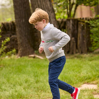 Little English traditional children's clothing. Grey intarsia sweater with 3 race cars layered over race car print turtleneck and paired with tapered navy sport pants for little boys.