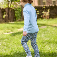 Little English traditional children's clothing. Long sleeve Hastings polo in light blue with ruffle collar and green floral detailing. Paired with green floral leggings for little girls.