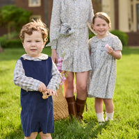Little English traditional children's clothing. Brown and blue Clarkson Plaid long sleeve peter pan shirt layered under navy corduroy button tab john john for toddler boys.