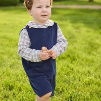 Little English traditional children's clothing. Brown and blue Clarkson Plaid long sleeve peter pan shirt layered under navy corduroy button tab john john for toddler boys.