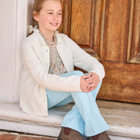 little english classic children's clothing girls cream cardigan with scalloped shawl collar and popcorn knot detailing, Hallie top in orange, blue, and green james floral, kick flare leggings in sky blue, outfit for fall
