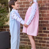 Little English classic children's clothing. White knit turtleneck with holiday train print layered under light blue corduroy Campbell Overall. White knit turtleneck with holiday present print layered under light pink corduroy Madison Jumper. Holiday outfit for little boys and girls.