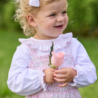 Little English traditional children's clothing. Light pink and green floral overall with ruffle detailing layered over white knit smocked Madeline Blouse in light pink