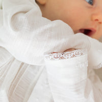 Little English traditional children's clothing. Unisex pleated ivory newborn gown with ruffles and embroidered detailing at the collar and sleeves