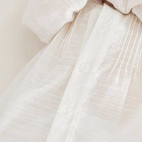 Little English traditional children's clothing. Unisex pleated ivory newborn gown with ruffles and embroidered detailing at the collar and sleeves