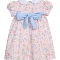 Little English traditional children's clothing. Classic peter pan dress with capped sleeves and a light blue sash in a light pink bunny print for little girls. Easter outfit for girls.
