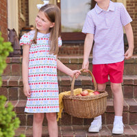Little English classic children's clothing. Short sleeve white knit peter pan dress with school themed print. Boys red and blue Primary Stripe short sleeve polo paired with red Sport Short. Back to school outfit for girls and boys.