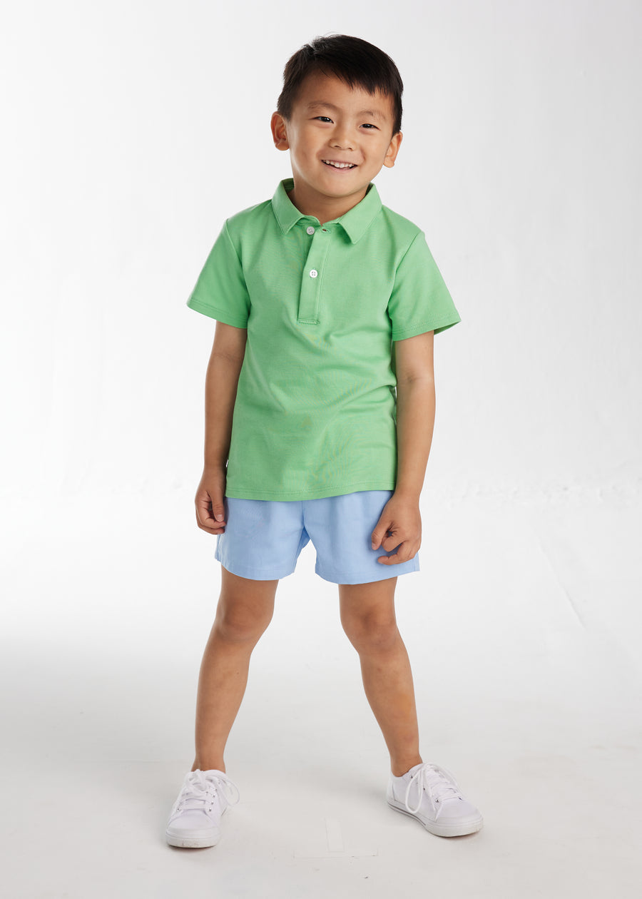 Little English classic clothing for kids, little boy's elastic waist short in light blue twill, pull on short for spring with green solid short sleeve polo
