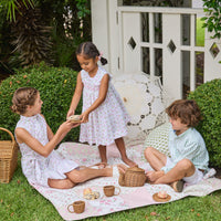 Little English traditional children's clothing. White sleeveless smocked dress with pink and green florals for little girls