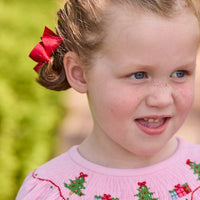 Little English traditional children's clothing. Long sleeve pink corduroy dress with Christmas motif smocking around the neckline for little girls.