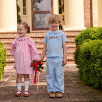 Little English traditional children's clothing. Long sleeve pink corduroy dress with Christmas motif smocking around the neckline for little girls. Boys blue corduroy set - banded pants paired with Eaton collar short sleeve top with holiday train smocking across the chest.