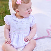 Little English traditional children's clothing. Dressy white bubble with floral smocking for baby girls for Spring. Special occasion outfit for baby girl