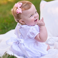 Little English traditional children's clothing. Dressy white bubble with floral smocking for baby girls for Spring. Special occasion outfit for baby girl