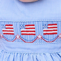 Little English traditional children's clothing.  Sleeveless bubble in royal blue mini check fabric and smocking at the chest with American flag bunting for baby boys