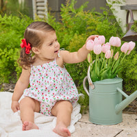 Little English traditional children's clothing.  White bubble with red and pink tulip print and fixed bow straps for baby girls