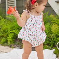 Little English traditional children's clothing.  White bubble with red and pink tulip print and fixed bow straps for baby girls