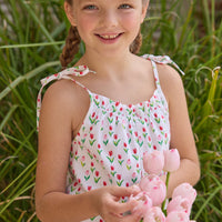 Little English traditional children's clothing.  White romper with red and pink tulip print and self-tie straps for little girls