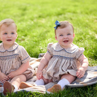 Little English classic children's clothing.  Smocked peter pan bubble in tan and blue Durham windowpane with puff sleeves and blue piping for baby girls