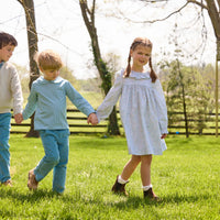 Little English traditional children's clothing.  Classic long sleeve peter pan shirt in blue Alpine Gingham paired with blue Alpine Corduroy pull on pants for toddler boys.  Older boys gray quarter zip sweater layered over blue Alpine Gingham button down shirt and paired with blue Alpine Corduroy classic pants. Ruffled collar long sleeve Bespoke Dress for little girls in blue and green Waterbury Floral
