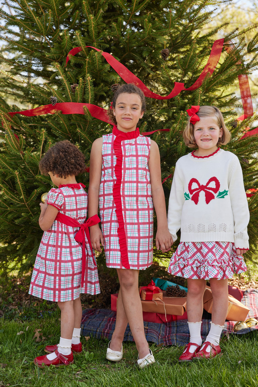 Little English classic tween girl dress in holiday plaid pattern with red ruffle running around neck and down front