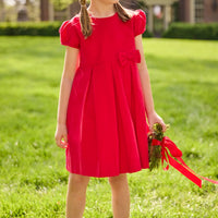 Little English traditional children's clothing.  Red corduroy dress with capped sleeves and off-center fixed bow at waist.  Holiday dress for little girls.