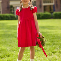 Little English traditional children's clothing.  Red corduroy dress with capped sleeves and off-center fixed bow at waist.  Holiday dress for little girls.