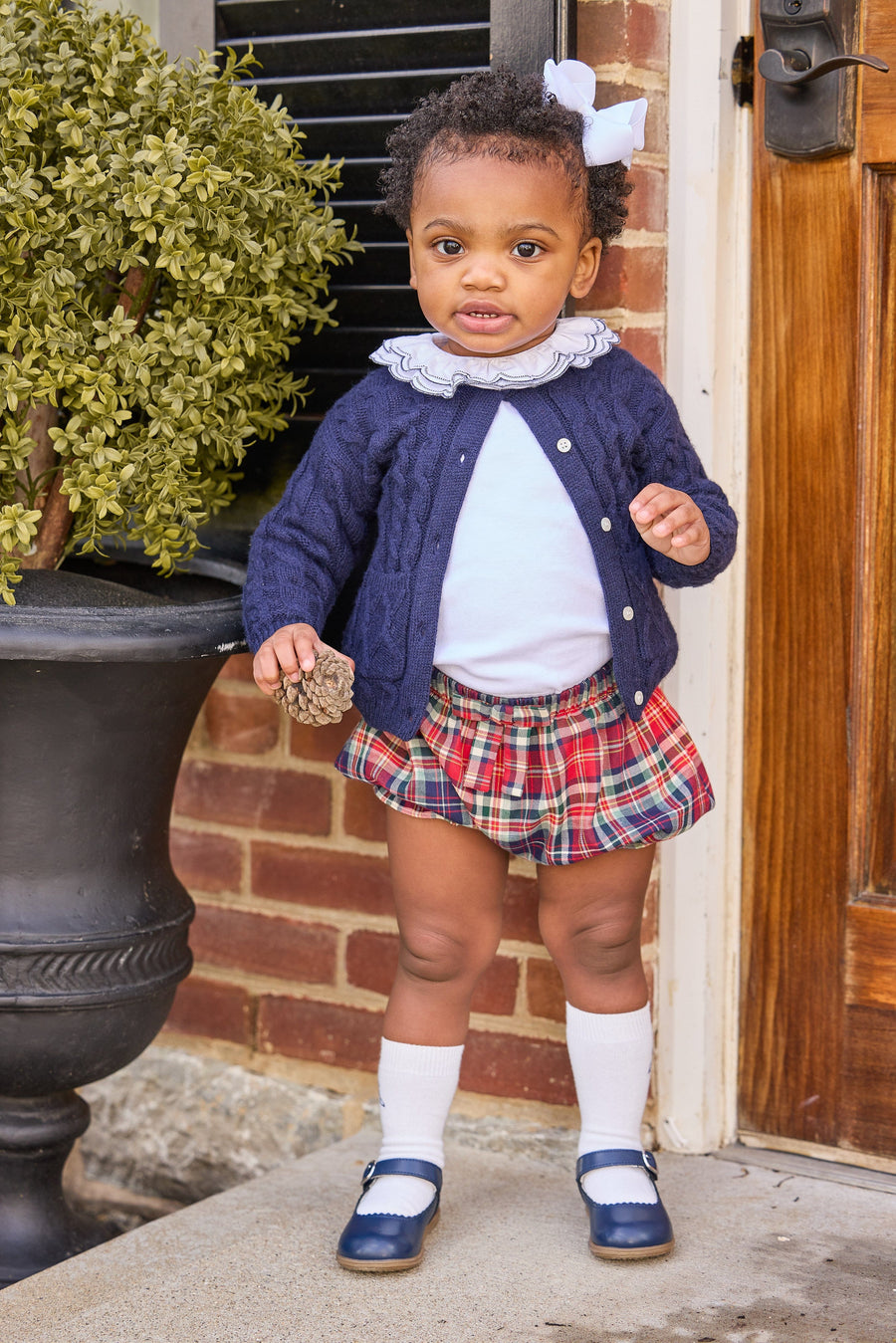 Little english classic children's clothing, cashmere blend cardigan in navy,  double london blouse with navy stitching on collar, bow bloomers in middleburg plaid, knee high socks with navy bow motif, fall outfit for little girl  