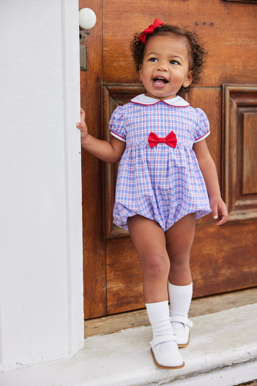 Little English classic baby girls bubble in red white and blue plaid pattern with a peter pan collar and red bow on waistline